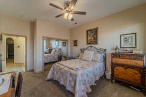 Carpeted bedroom featuring ceiling fan