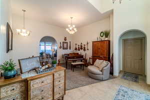 Interior space with a high ceiling, light carpet, and an inviting chandelier