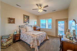 Carpeted bedroom featuring ceiling fan and access to exterior