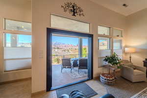 Doorway featuring light tile patterned floors, a towering ceiling, and a mountain view