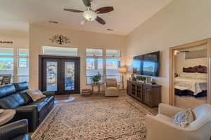 Carpeted living room featuring french doors and ceiling fan