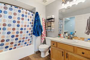 Full bathroom with vanity, tile patterned flooring, toilet, and shower / bath combo with shower curtain