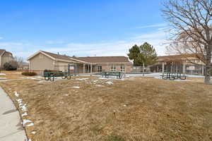 Back of property featuring a community pool and a lawn