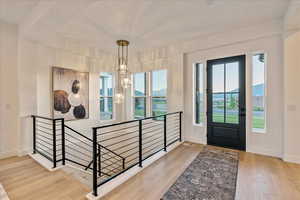 Entryway with a chandelier and light hardwood / wood-style floors