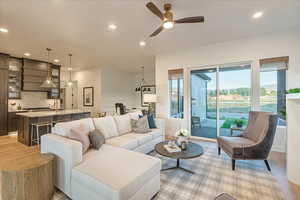 Living room featuring ceiling fan, sink, and light hardwood / wood-style flooring