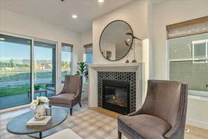 Sitting room with a tile fireplace and light wood-type flooring