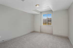 Empty room with carpet flooring and a textured ceiling