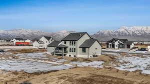 Snow covered rear of property with a mountain view