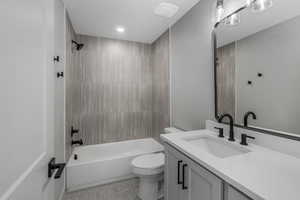 Full bathroom with vanity, toilet, and tiled shower / bath