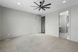 Unfurnished bedroom with ensuite bathroom, carpet floors, and ceiling fan