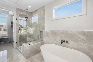 Bathroom with shower with separate bathtub and tile walls