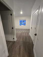 Hallway featuring dark colored carpet