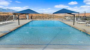 View of pool with pool water feature, a mountain view, and a patio area