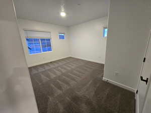 Spare room featuring dark carpet