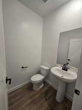 Bathroom with hardwood / wood-style flooring and toilet