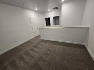 Spare room with dark colored carpet