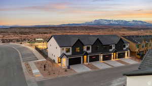 View of front of house featuring a mountain view, driveway, an attached garage, and stucco siding