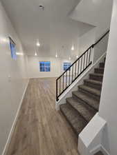 Stairs featuring hardwood / wood-style floors