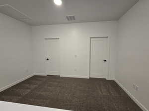 Spare room with dark colored carpet