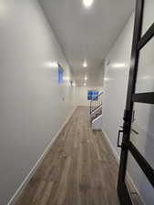 Hallway with hardwood / wood-style flooring