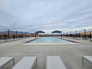 View of pool with a mountain view and a patio