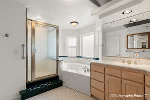 Bathroom with vanity, tile patterned flooring, plus walk in shower, and a textured ceiling