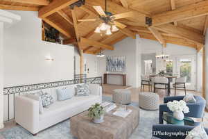 Living room with an inviting chandelier, high vaulted ceiling, wood ceiling, beam ceiling, and french doors