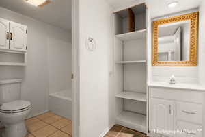 Full bathroom featuring tile patterned floors, toilet, vanity, and plus walk in shower