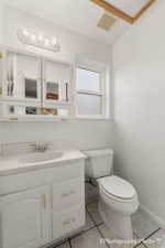 Bathroom featuring vanity, toilet, and tile patterned flooring