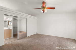 Unfurnished bedroom with vaulted ceiling, carpet floors, sink, ceiling fan, and a closet