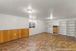 Interior space with a textured ceiling and wood walls