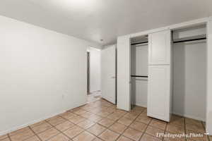 Unfurnished bedroom featuring light tile patterned flooring