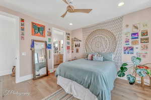 Bedroom with hardwood floors, ceiling fan, and ensuite bathroom