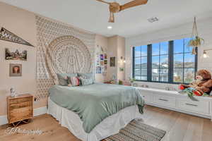 Bedroom featuring light hardwood floors and ceiling fan, views to north mountains