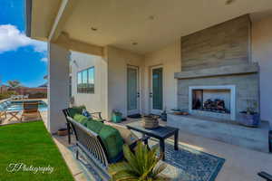 View of covered patio featuring a fireplace and half bath