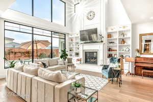 Living room featuring a towering ceiling and light hardwood