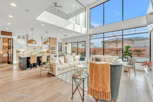 Living room featuring light hardwood flooring and glass floor to second level.