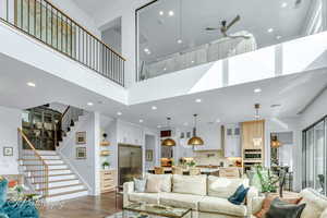 Living room with a high ceiling, hardwood floors.