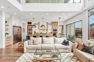 Living room featuring light hardwood flooring and a high ceiling