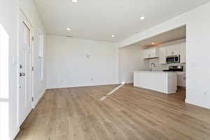 Unfurnished living room with sink and light hardwood / wood-style floors