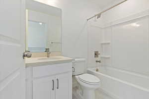 Full bathroom with shower / washtub combination, toilet, tile patterned flooring, and vanity