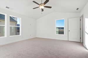 Carpeted spare room featuring ceiling fan and lofted ceiling