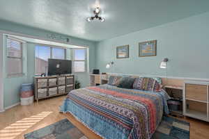 Bedroom featuring light hardwood / wood-style flooring and a textured ceiling