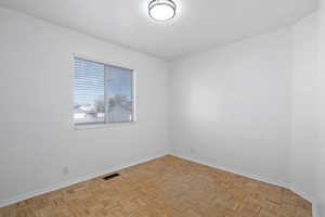 Empty room with light parquet floors