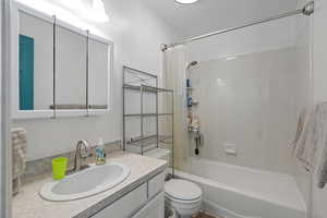 Full bathroom featuring vanity, toilet, and shower / bath combo with shower curtain