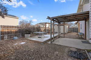 View of yard featuring a deck, a patio area, and a shed