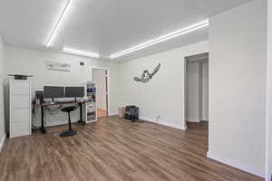 Office space featuring wood-type flooring and a textured ceiling