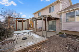 Deck featuring a patio, a pergola, and a shed