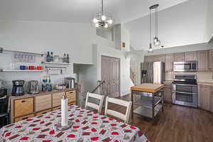 Kitchen with stainless steel appliances, tasteful backsplash, dark hardwood / wood-style flooring, and decorative light fixtures