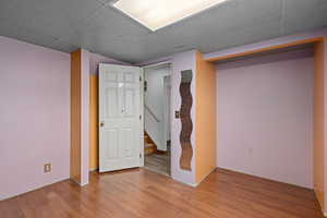 Basement with hardwood / wood-style flooring and a paneled ceiling